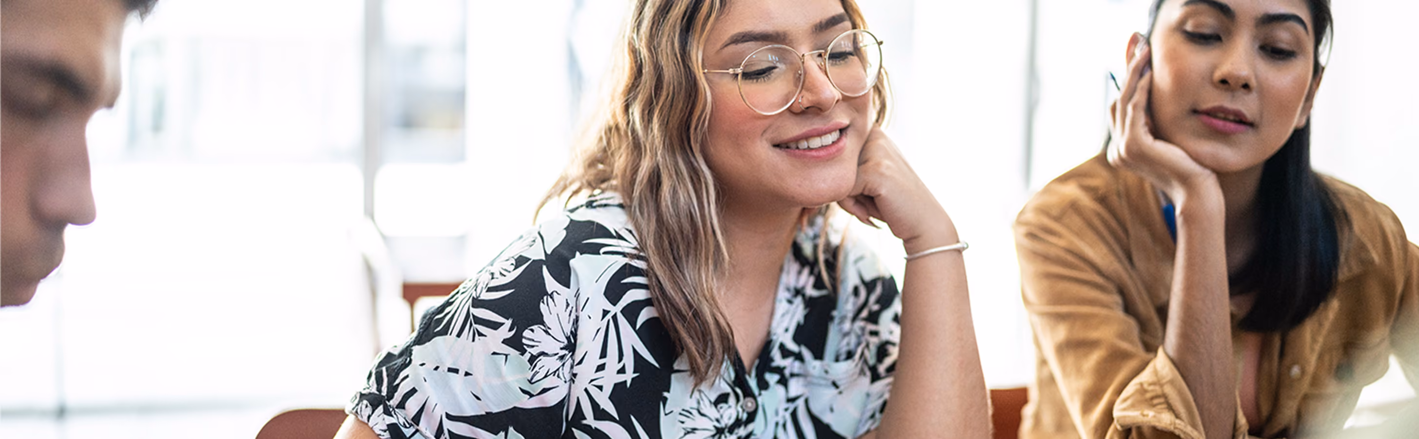 Woman in glasses working with another Gen Z woman on a project