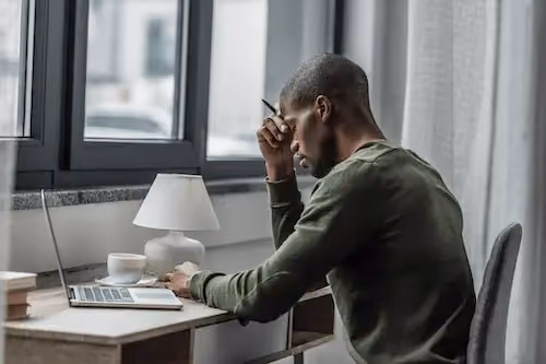 Black man with a pen in his hand working