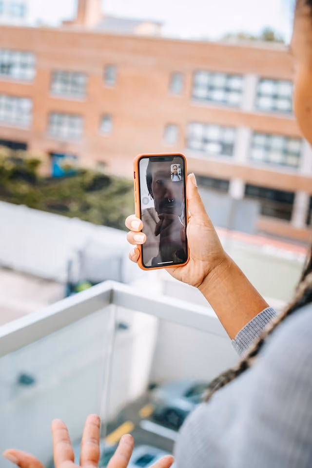 Woman taking an online teletherapy call from her balcony