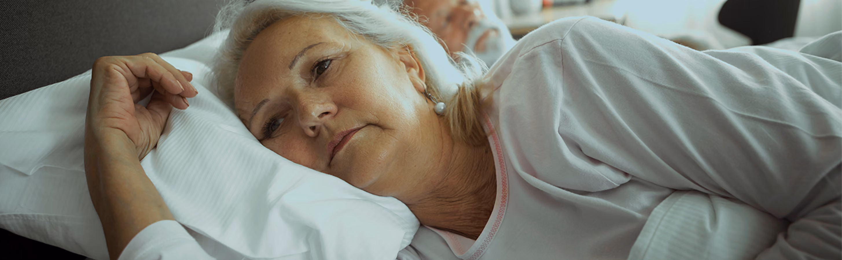 Woman lying in bed in deep thought