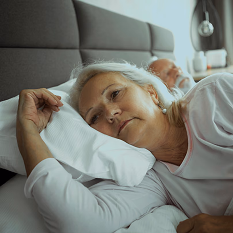 Woman lying in bed in deep thought