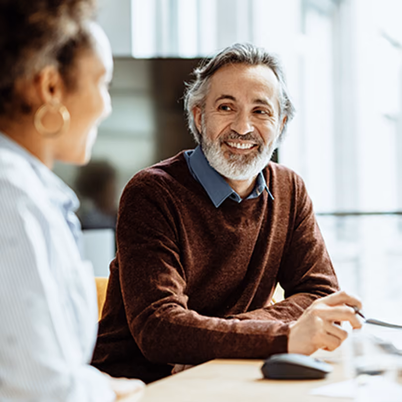 Older man with a beard talking with a healthcare professional