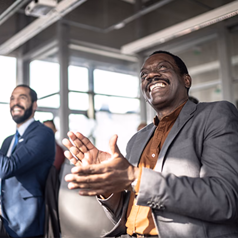 Two men clapping to congratulate a work colleague