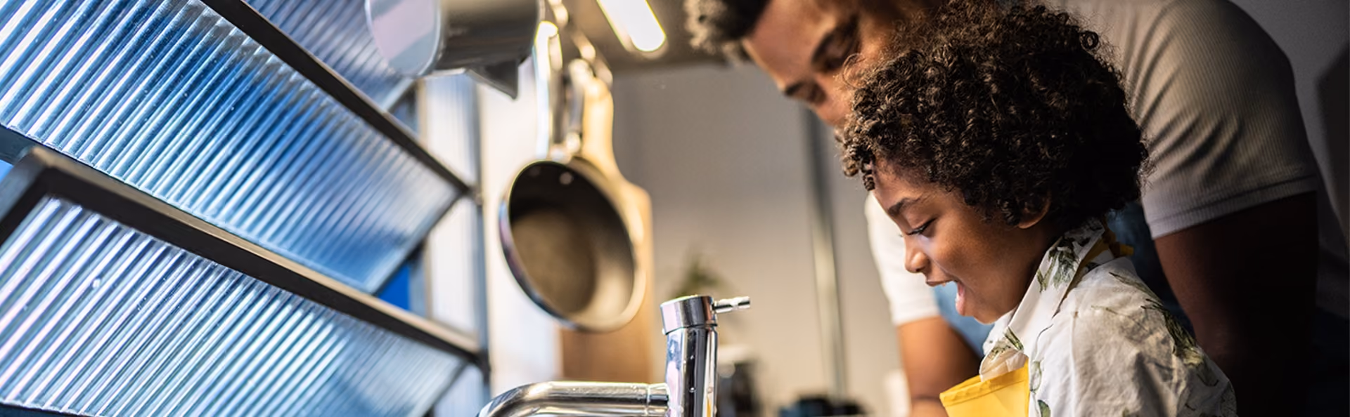 dad washes the dishes with his young son