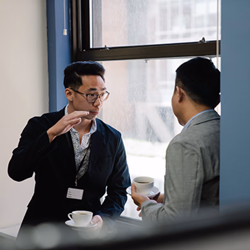 Two men discussing business in a hallway