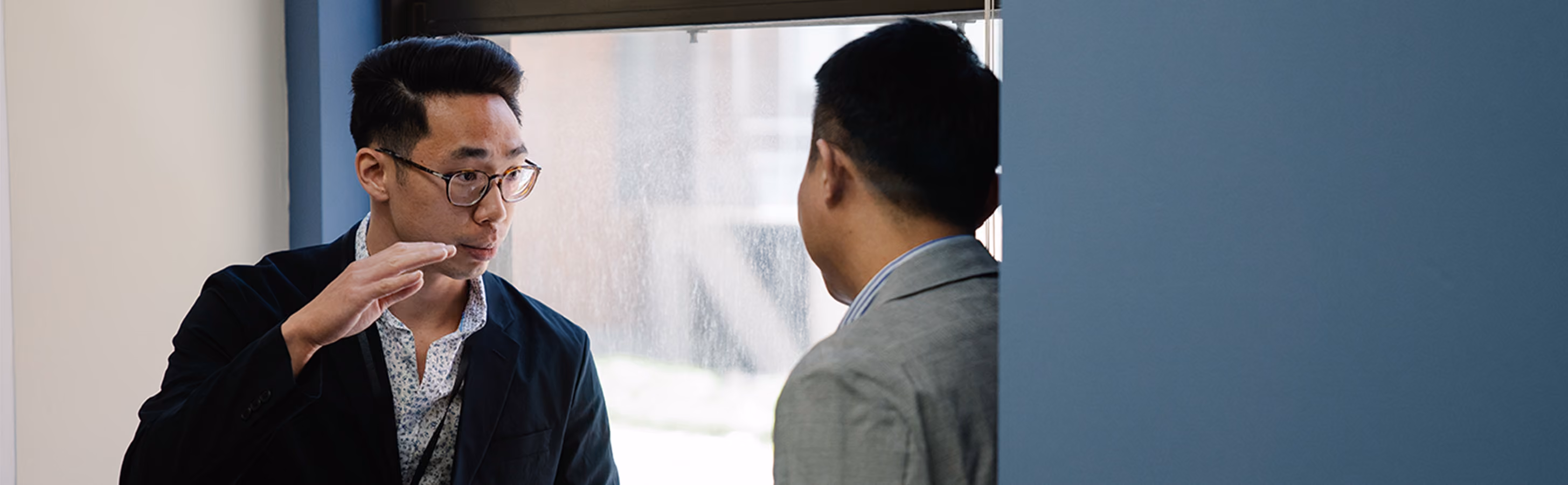 Two men discussing business in a hallway