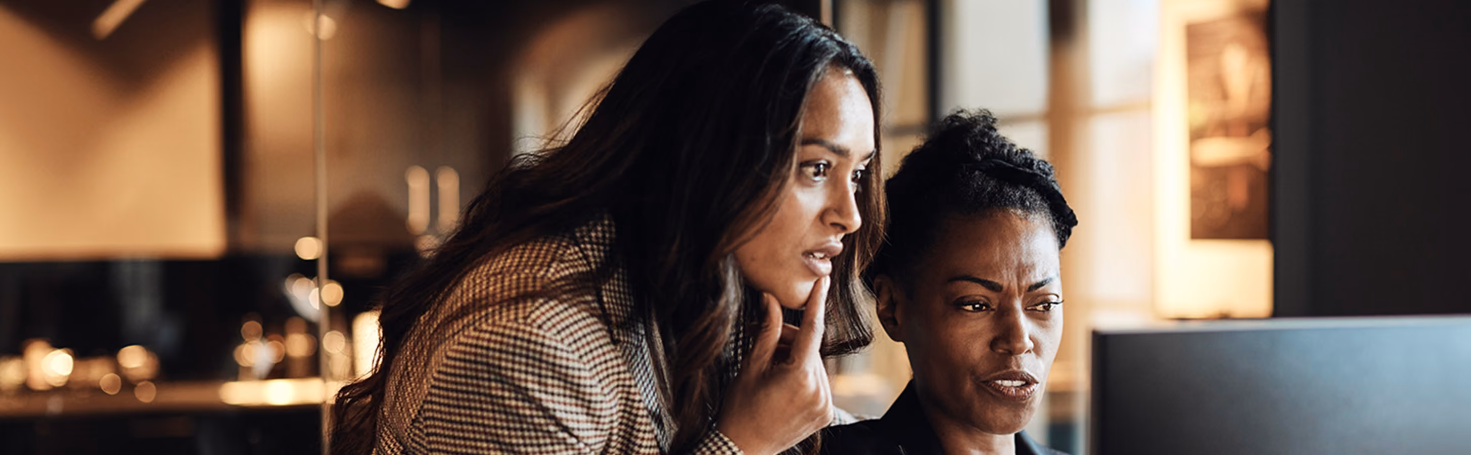 A female manager discussing a work topic with a female employee in the office