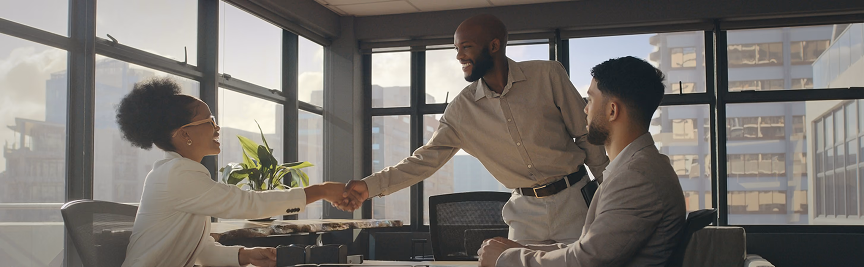 A businessman shakes hands with a businesswoman as they prepare for a meeting