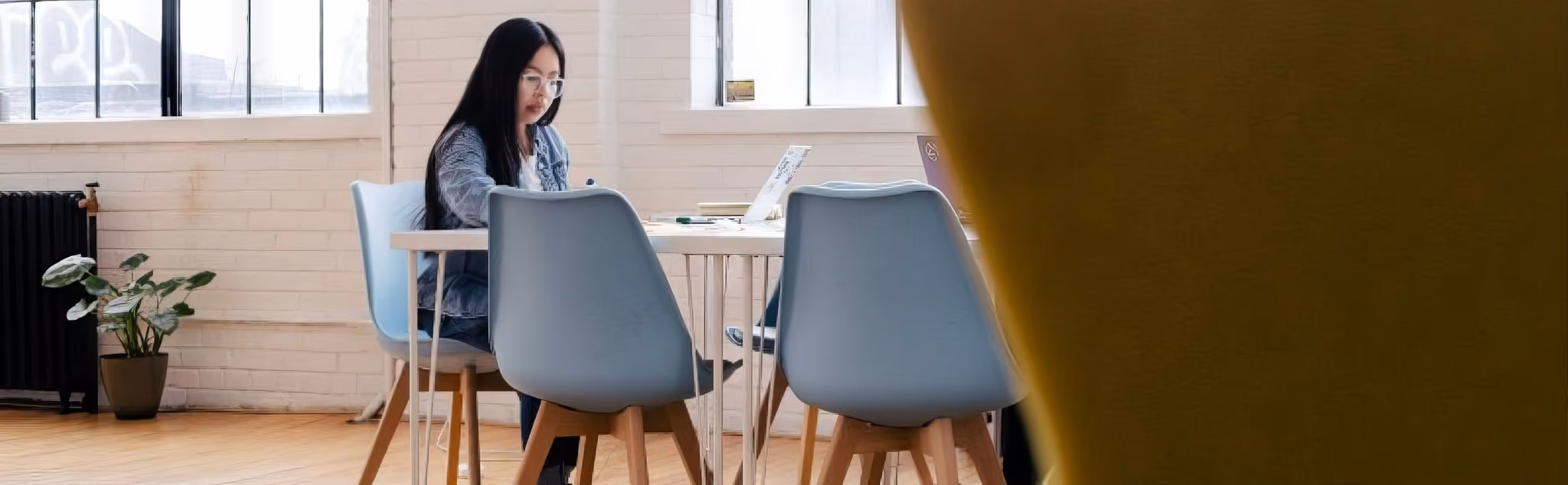 A woman working by herself in the office on a laptop