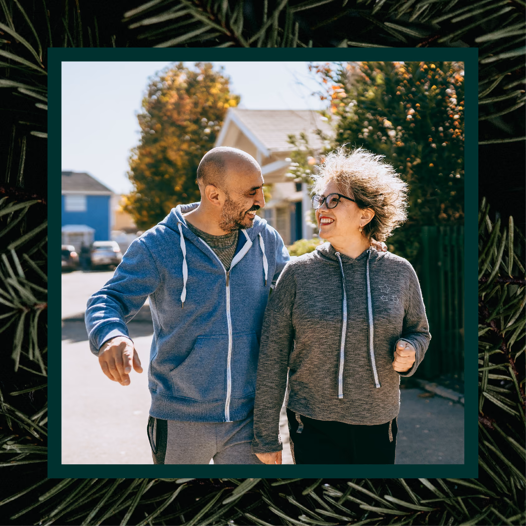 A man and woman smiling at each other as they walk down a street
