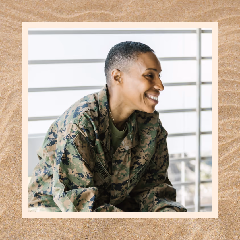 An army officer smiling while sitting down