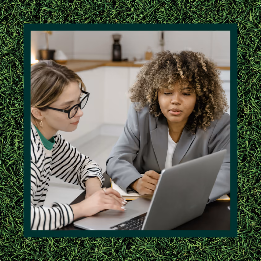 A manager and employee working on a computer together
