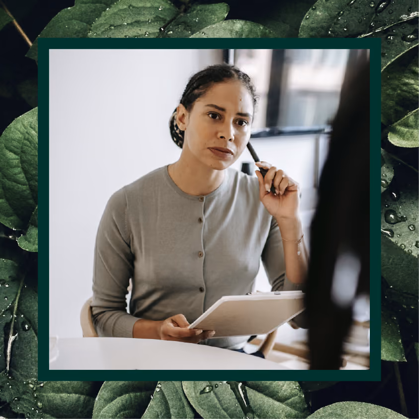 A therapist listening to a patient while taking notes