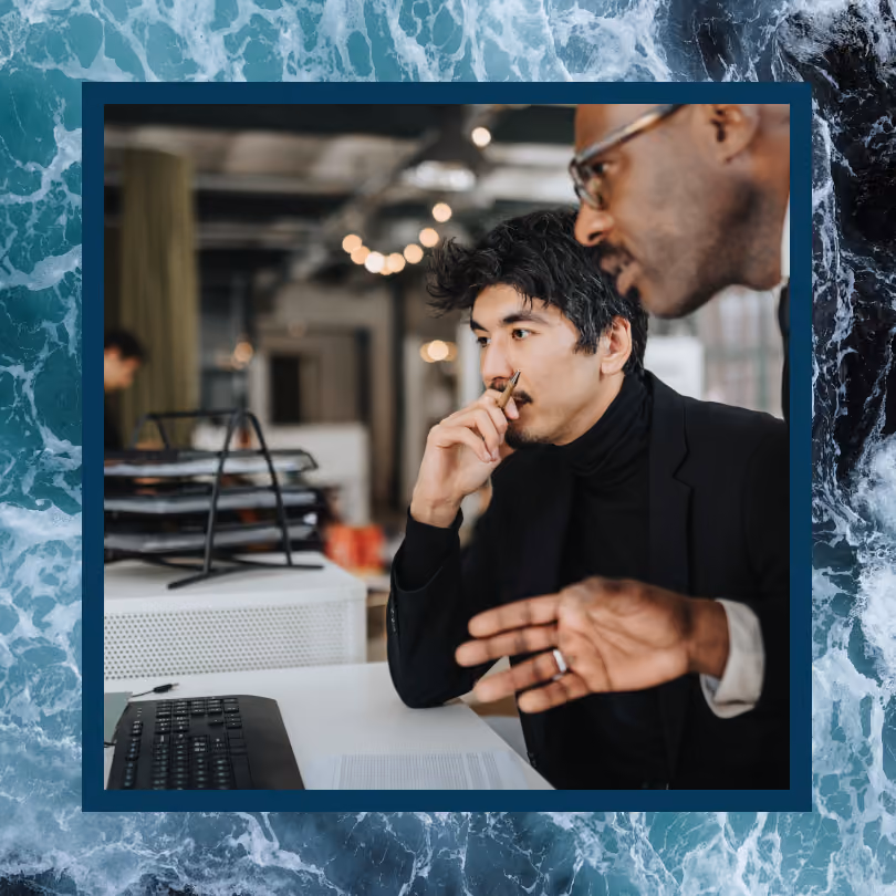 Two men collaborate at an office desk