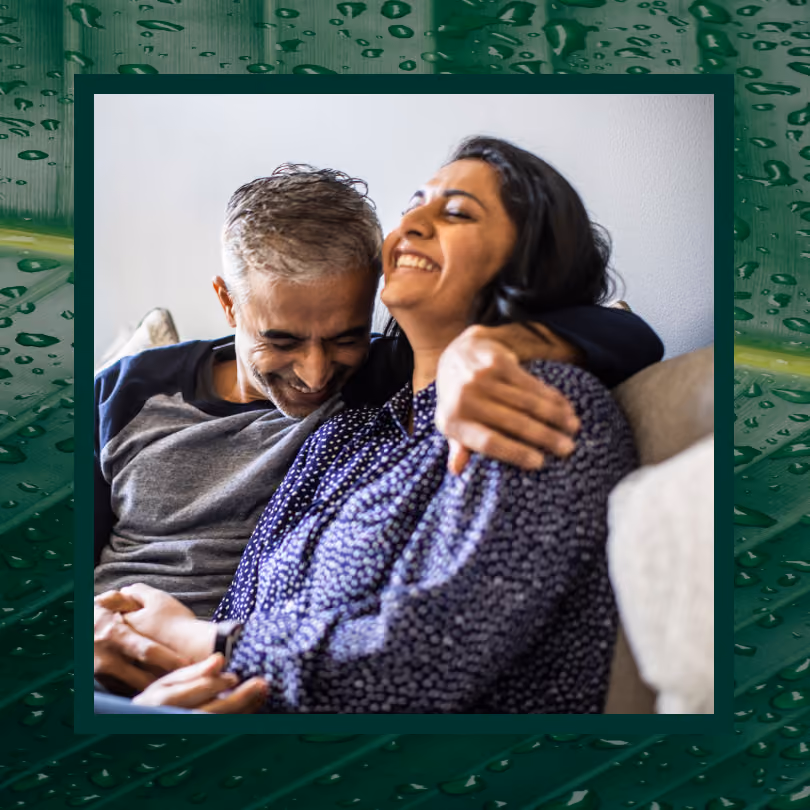 A man and woman wrapped in an embrace laughing