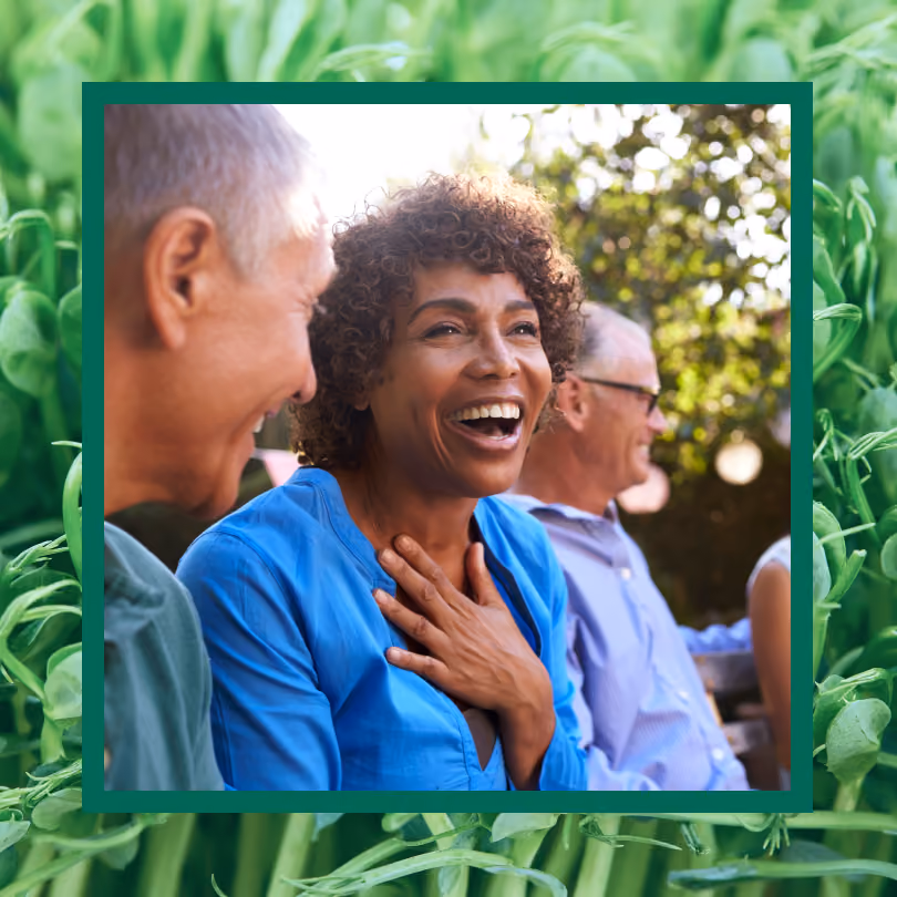 A woman laughing with friends outside