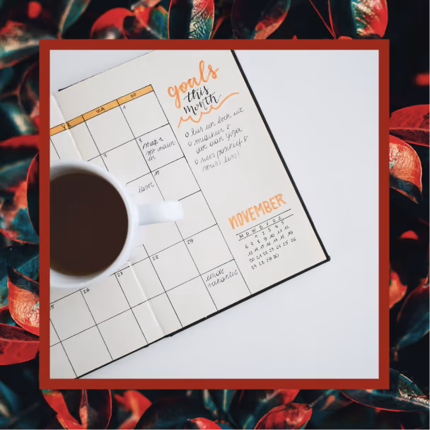 A goals calendar with a cup of coffee sitting on it
