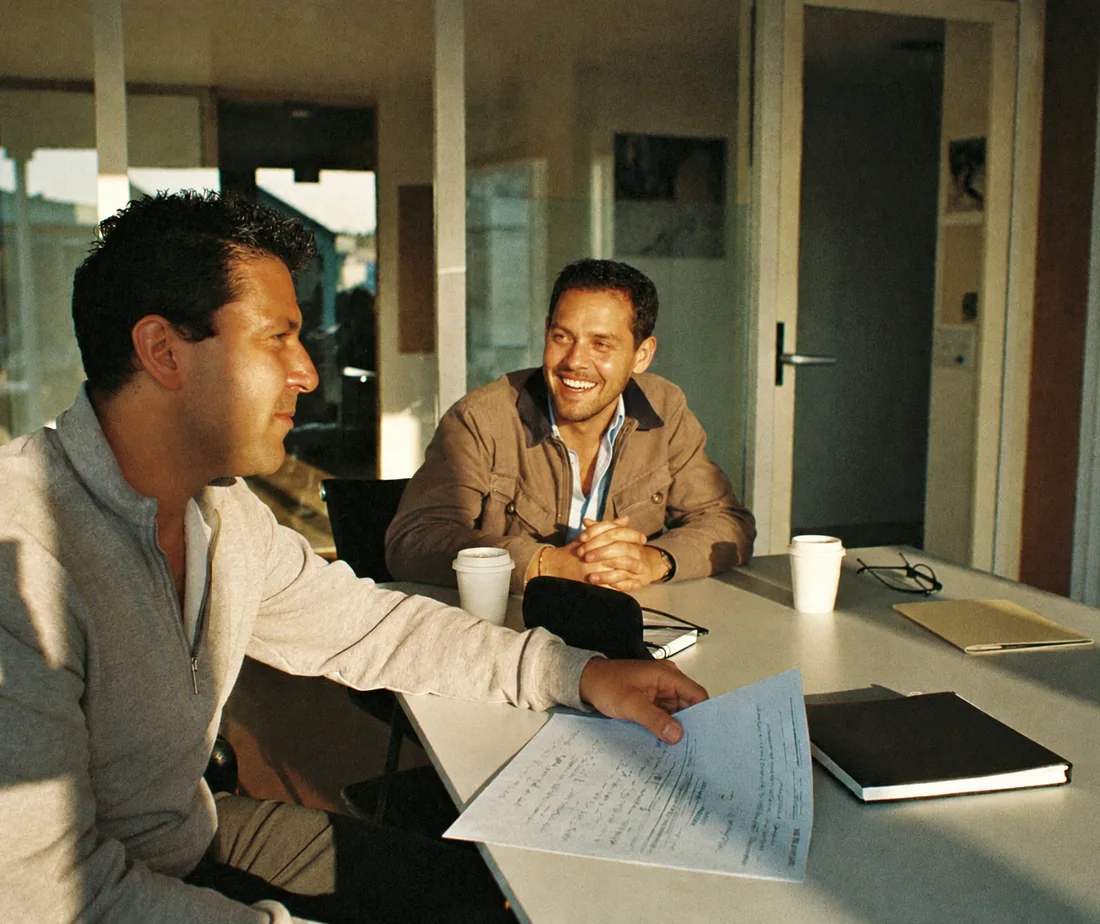 An accountant reviewing marked-up financials with a client in a sunlit conference room