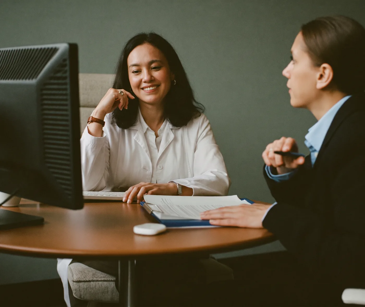 A physician practice owner discussing a financial report with a finance advisor