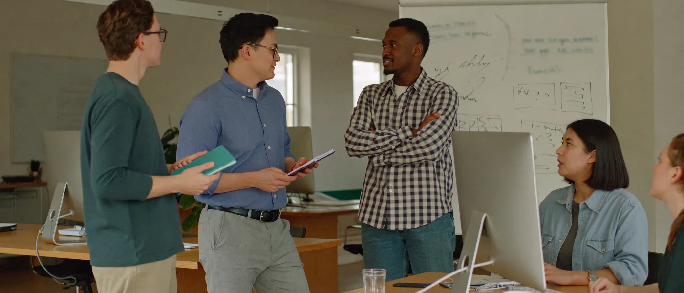 A SaaS company team talking around a whiteboard