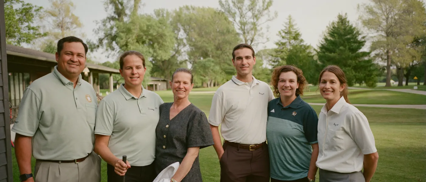 A golf course staff team on the clubhouse lawn