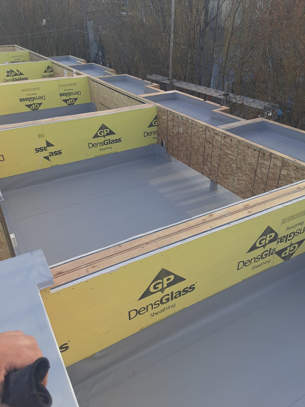 TPO membrane installed over roof sheathing on a multi-section commercial flat roof