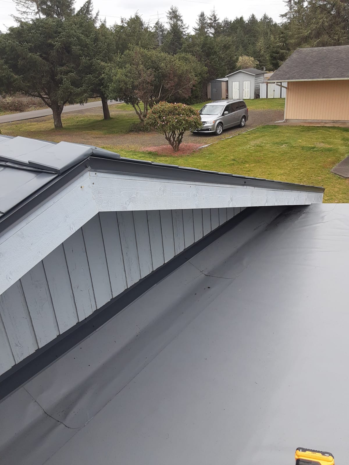 Flat, low-slope PVC membrane roof section next to a metal standing-seam roof