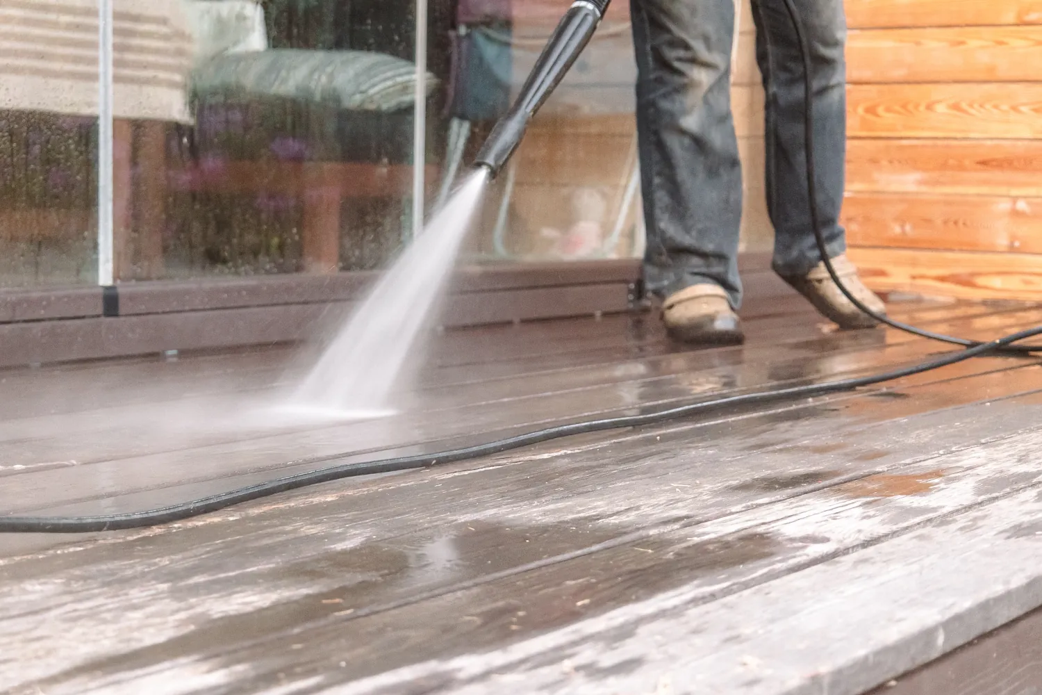 Professional power washing a weathered wood deck in Bellevue before staining as part of deck painting prep