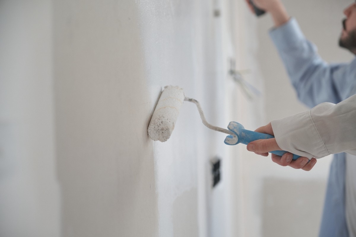 Painting contractors applying primer on a wall before painting starts