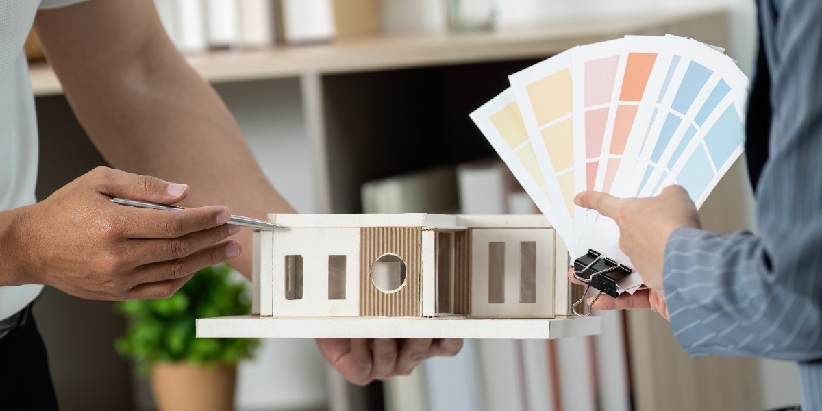 A contractor holding a house miniature explaining the best exterior color that hold up in Bellevue
