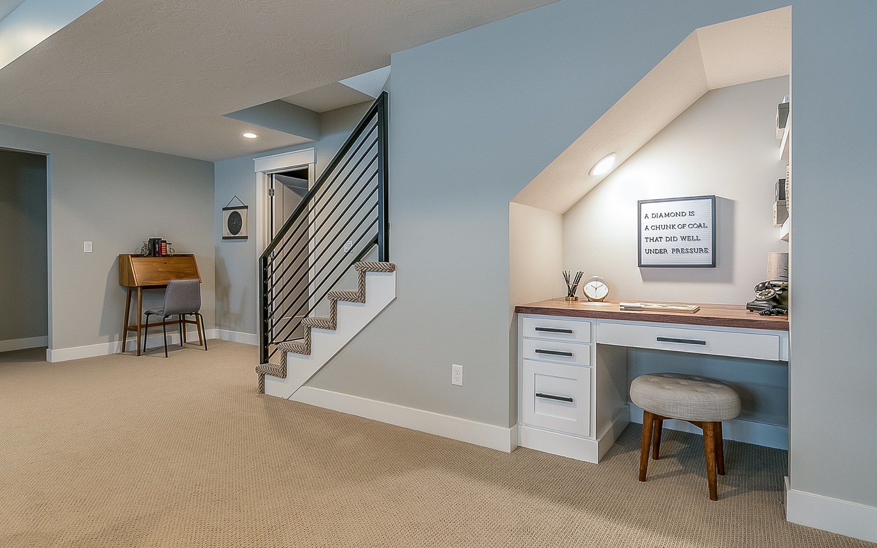 Basement room with home office desk underneath the stairs