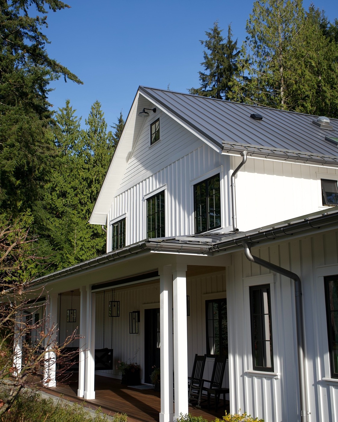 Freshly painted white house exterior with vertical siding, clean trim, and a covered porch, showcasing a bright, modern exterior painting finish that boosts curb appeal