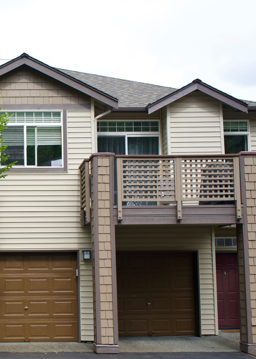 Townhouse exterior with newly painted siding, trim, and garage doors in a residential community