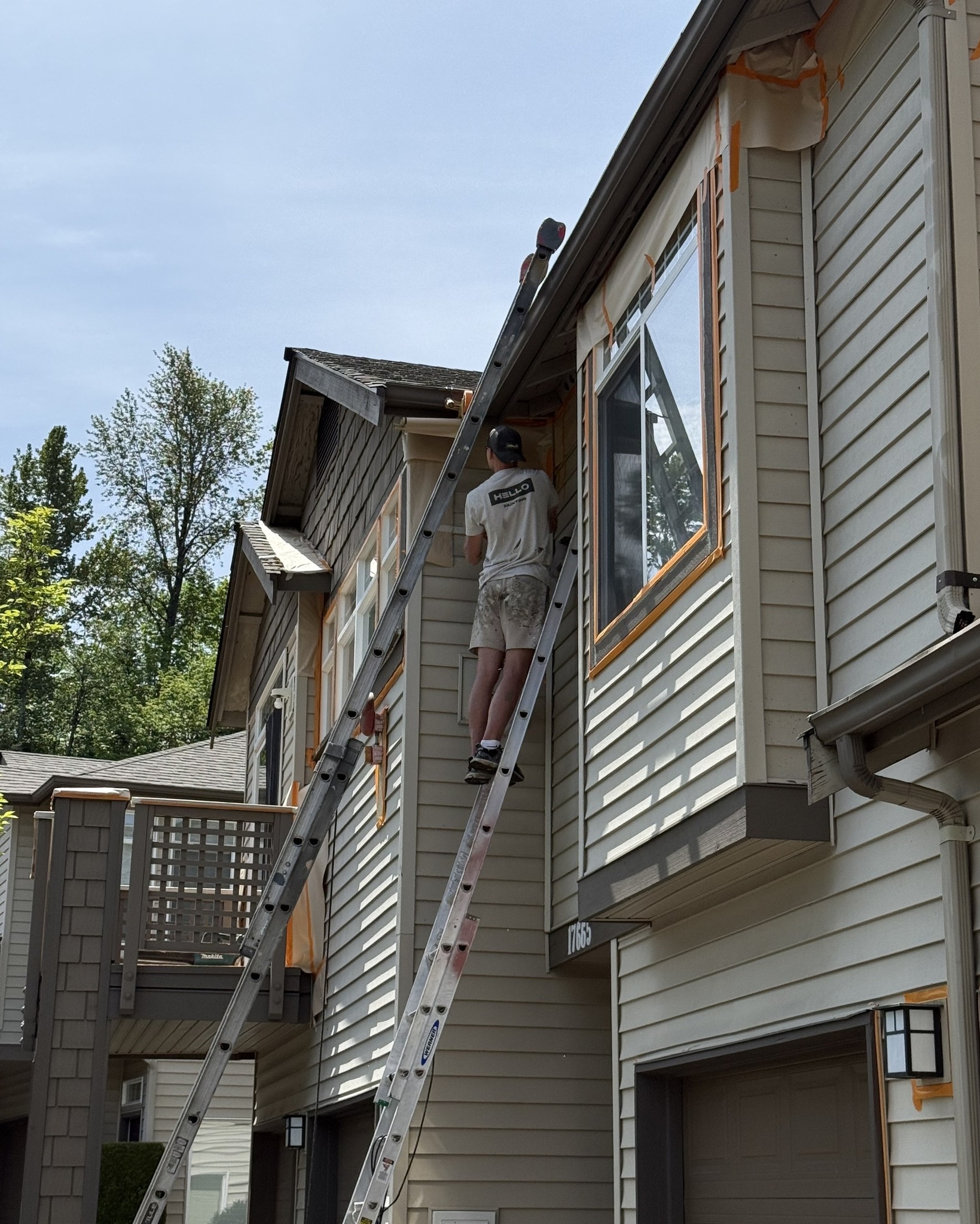 Residential exterior painting in progress with HELLO Painting contractor painting home siding