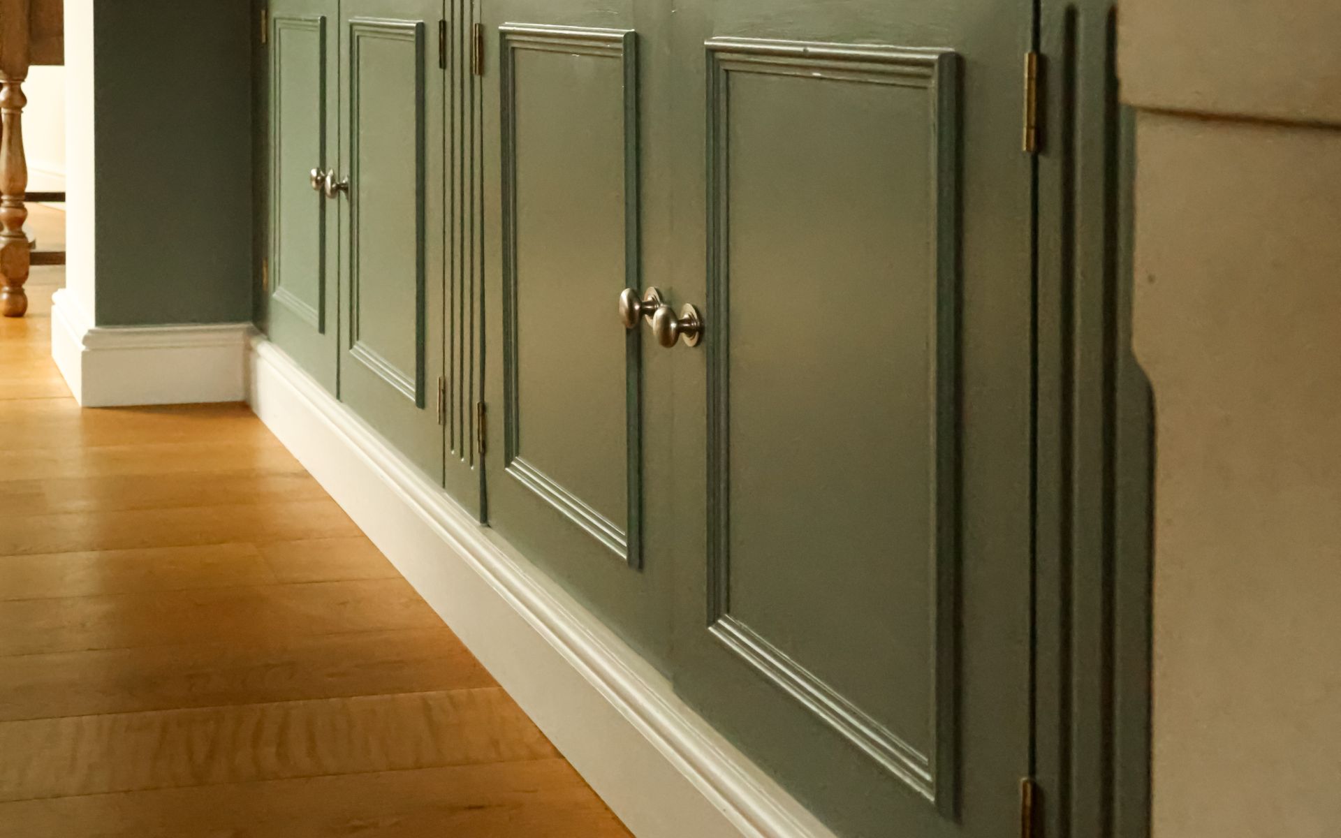 Traditional wood kitchen cabinet doors painted green with metal knobs