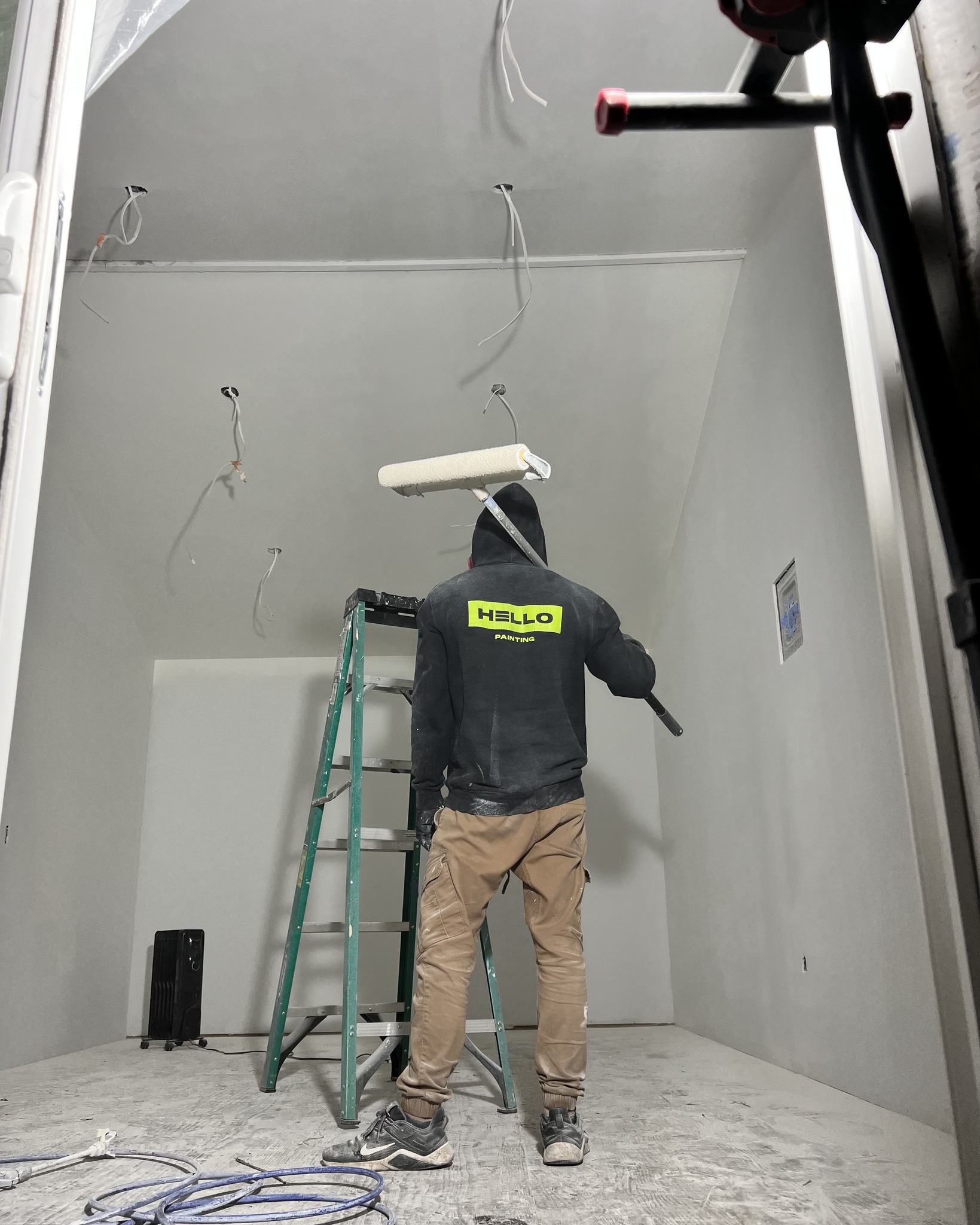 HELLO Painting contractor painting a residential interior ceiling as part of a professional interior painting service