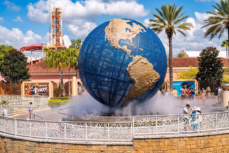 Universal Studios Florida entrance with the iconic rotating globe and visitors walking around