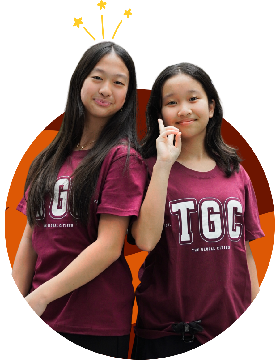 Two girls wearing matching maroon TGC t-shirts standing side by side, one smiling with a hand gesture and the other with drawn yellow stars above her head.