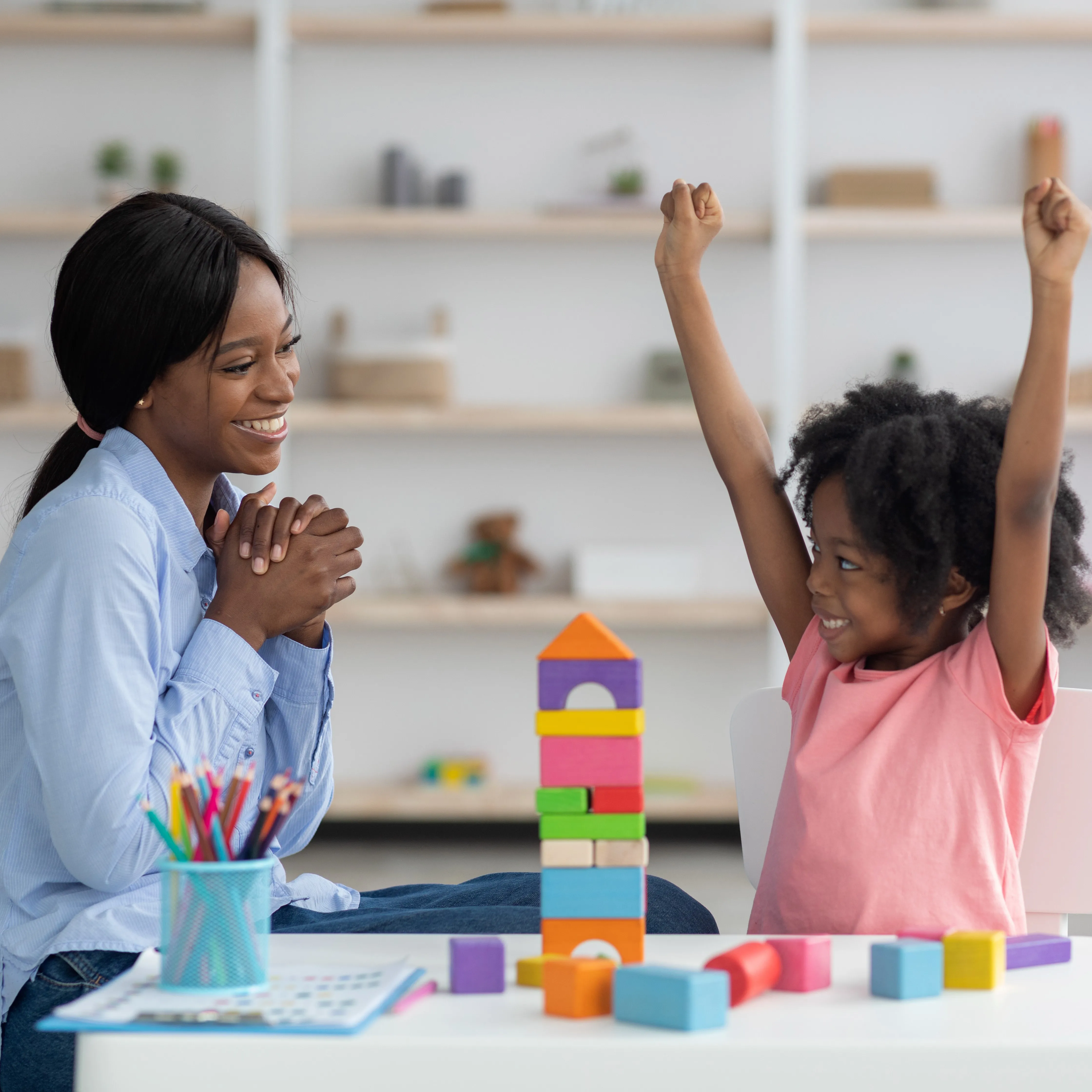 A woman and child celebrating their block tower.