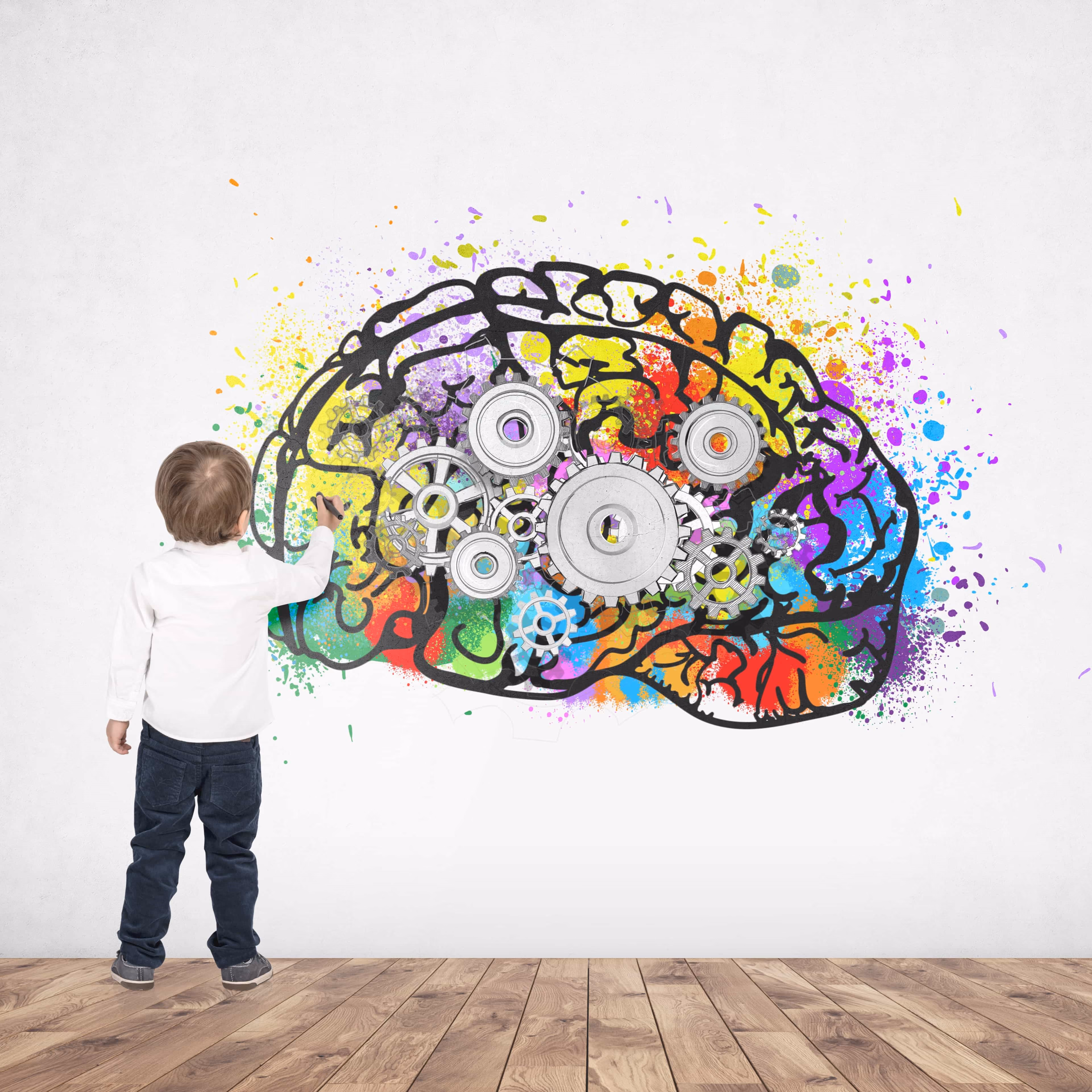 A child painting a colorful brain on the wall. 
