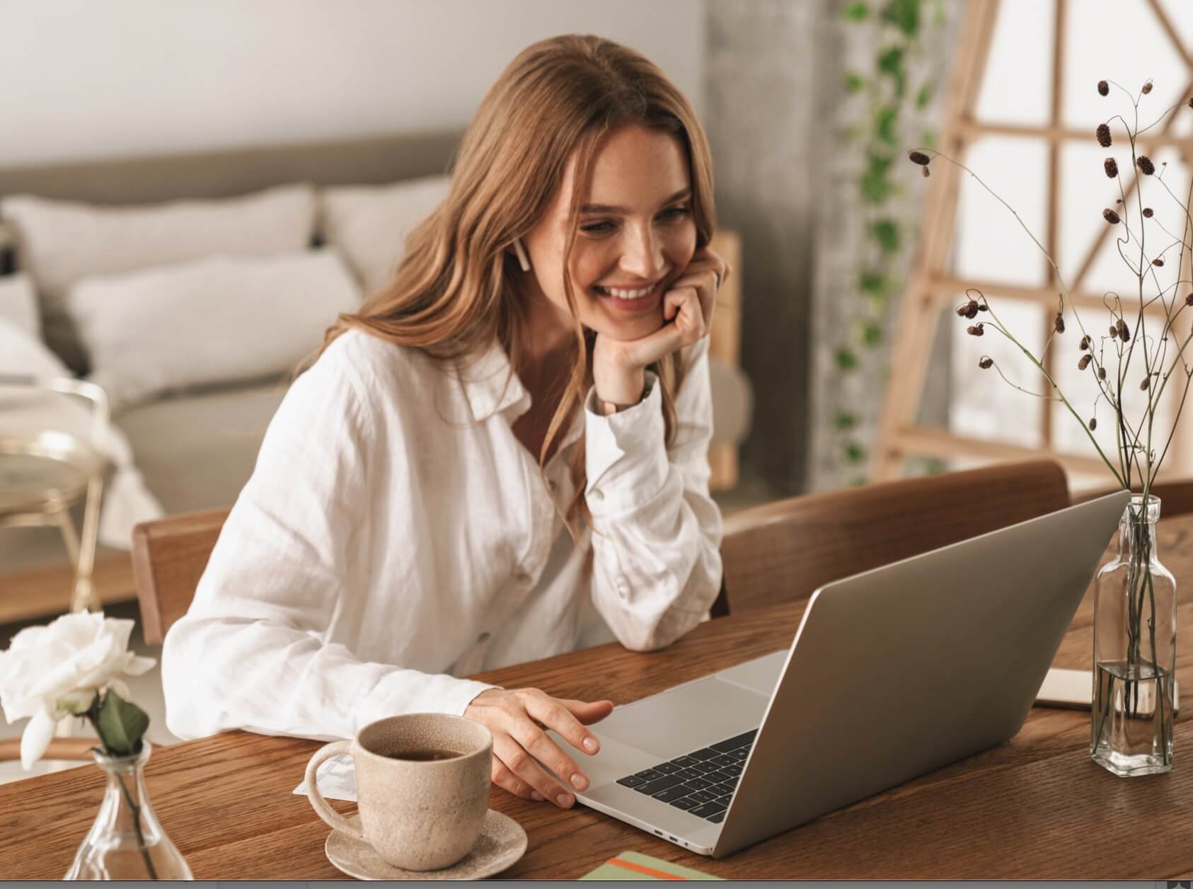 A Young Woman Sitting In Front of Her Laptop Smiling