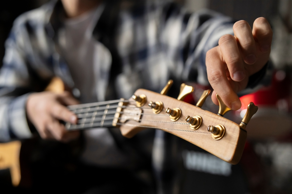 A musician fine tuning his guitar.