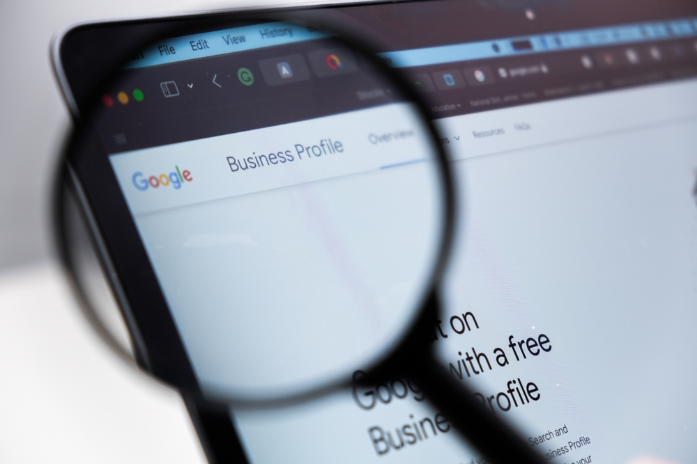 A magnifying glass hovering over the Google Business Profile logo. 