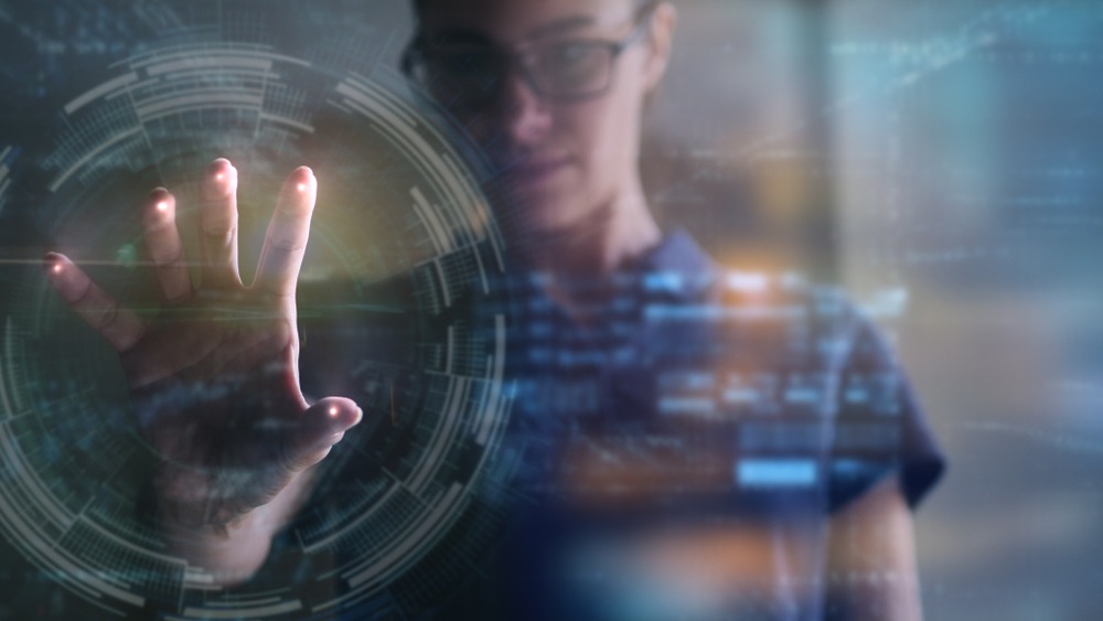 A woman pressing her hand to a digital graphic looking inquisitive.
