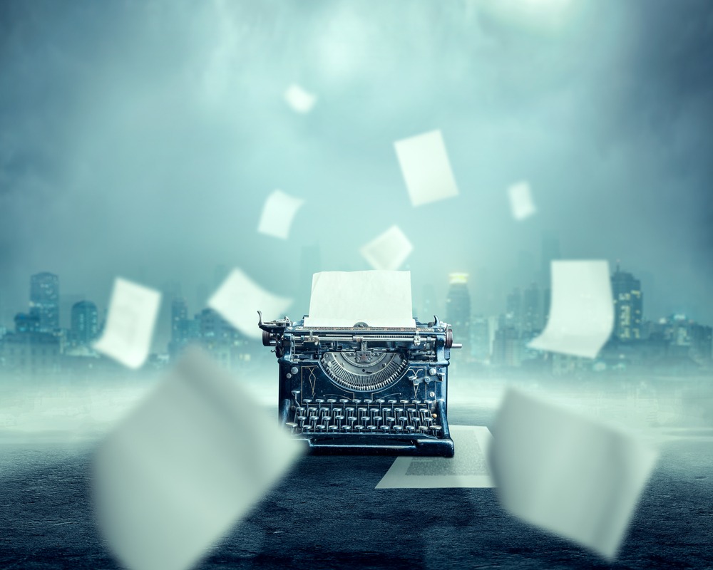 An old school typewriter with pages flying past it.