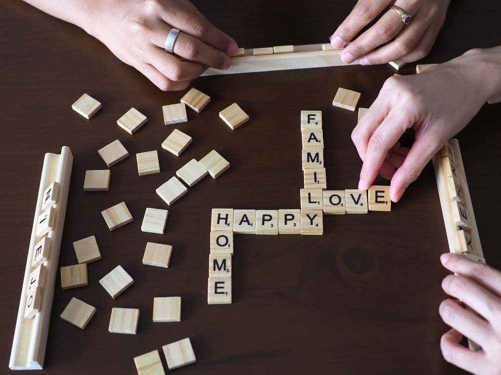 People playing Scrabble with various words on the table representing topic clusters.