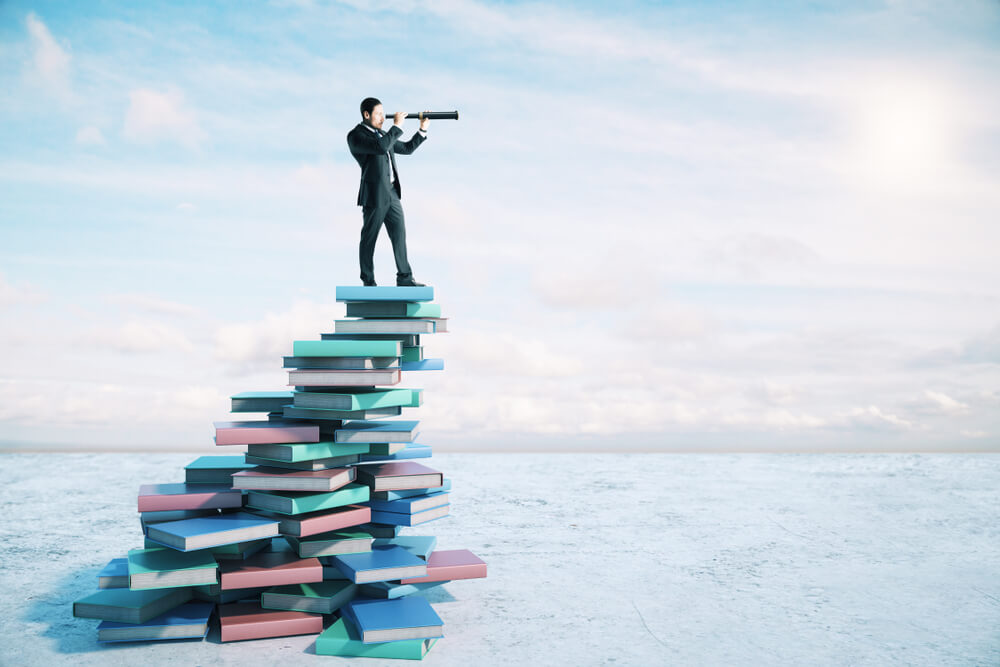 Career,Growth,And,Development,Concept,With,Businessman,On,Book,Mountain