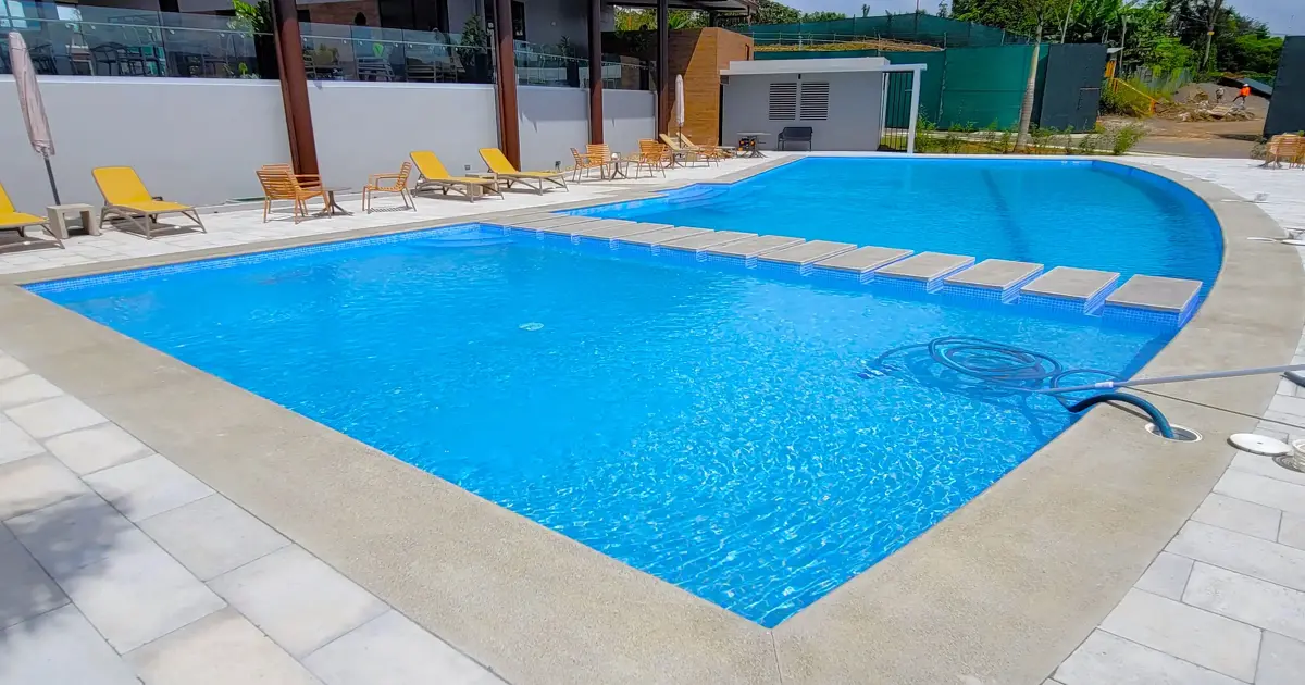 Piscina comunitaria en condominio con acabados premium.