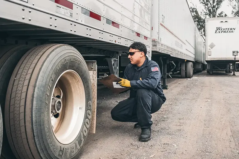 Technician performs preventive maintenance on a semi-trailer for Galesburg–Davenport delivery cycles.