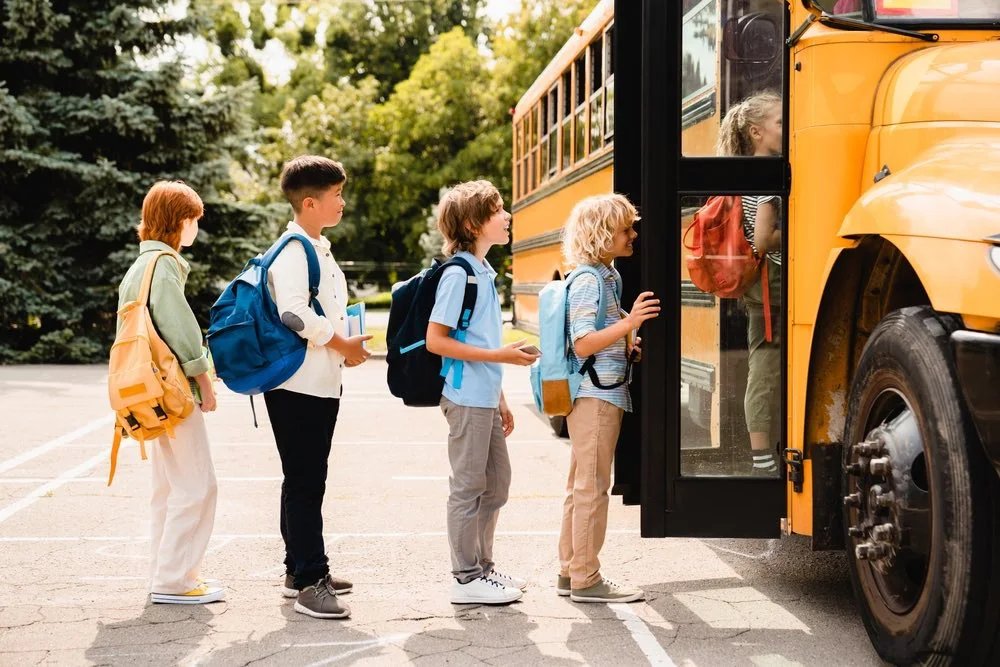 Children boarding a school bus, illustrating the types of evidence involved in teacher and coach abuse cases.